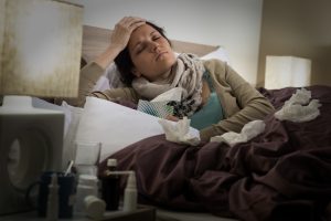Sick woman in bed suffering flu headache